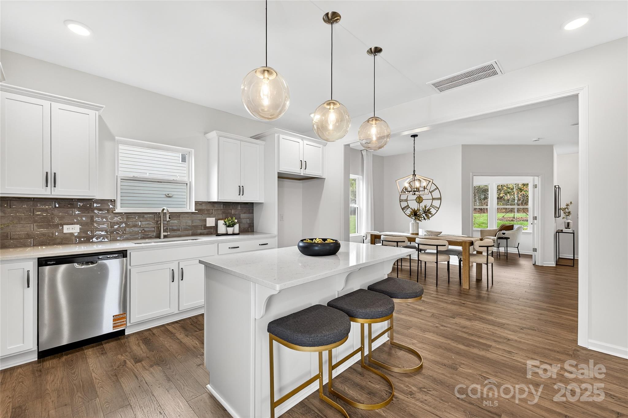 10423 Lakeshore Drive, Unit 71 Lancaster, SC 29720 - Photo 6 of 31 a kitchen with stainless steel appliances granite countertop a stove a sink a dining table and chairs with wooden floor