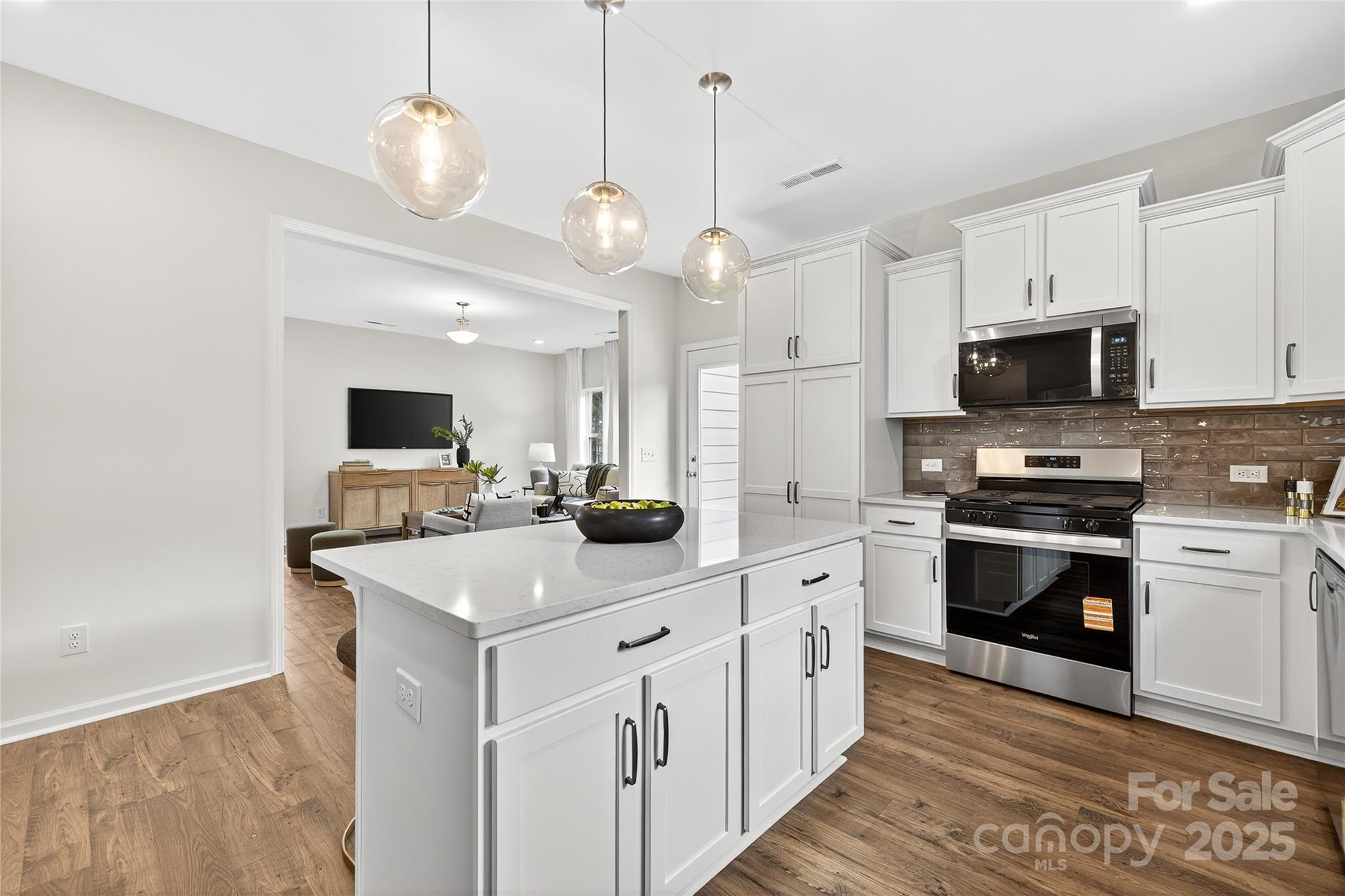 10423 Lakeshore Drive, Unit 71 Lancaster, SC 29720 - Photo 7 of 31 a kitchen with stainless steel appliances a stove top oven a sink dishwasher and a refrigerator with wooden floor