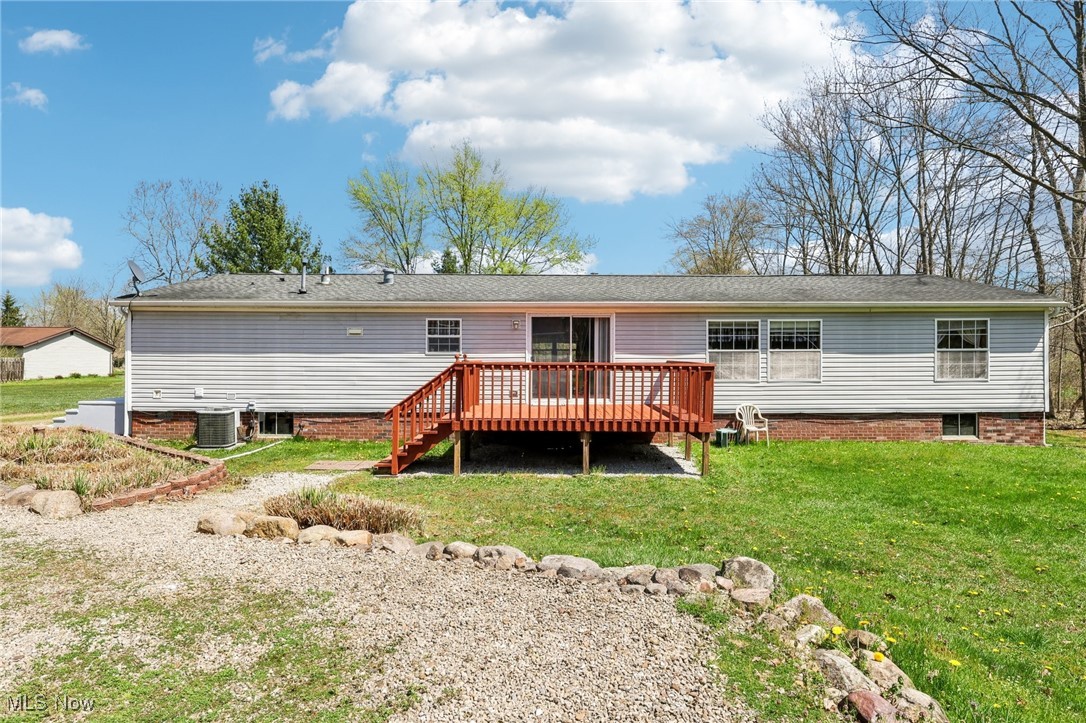 8307 Slagle Road Windham, OH 44288 - Photo 35 of 39 Back of property featuring a lawn, a deck, and central AC