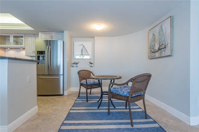 a kitchen with stainless steel appliances wooden floor and chairs