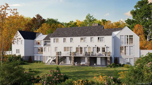 a view of a white house with a big yard and potted plants