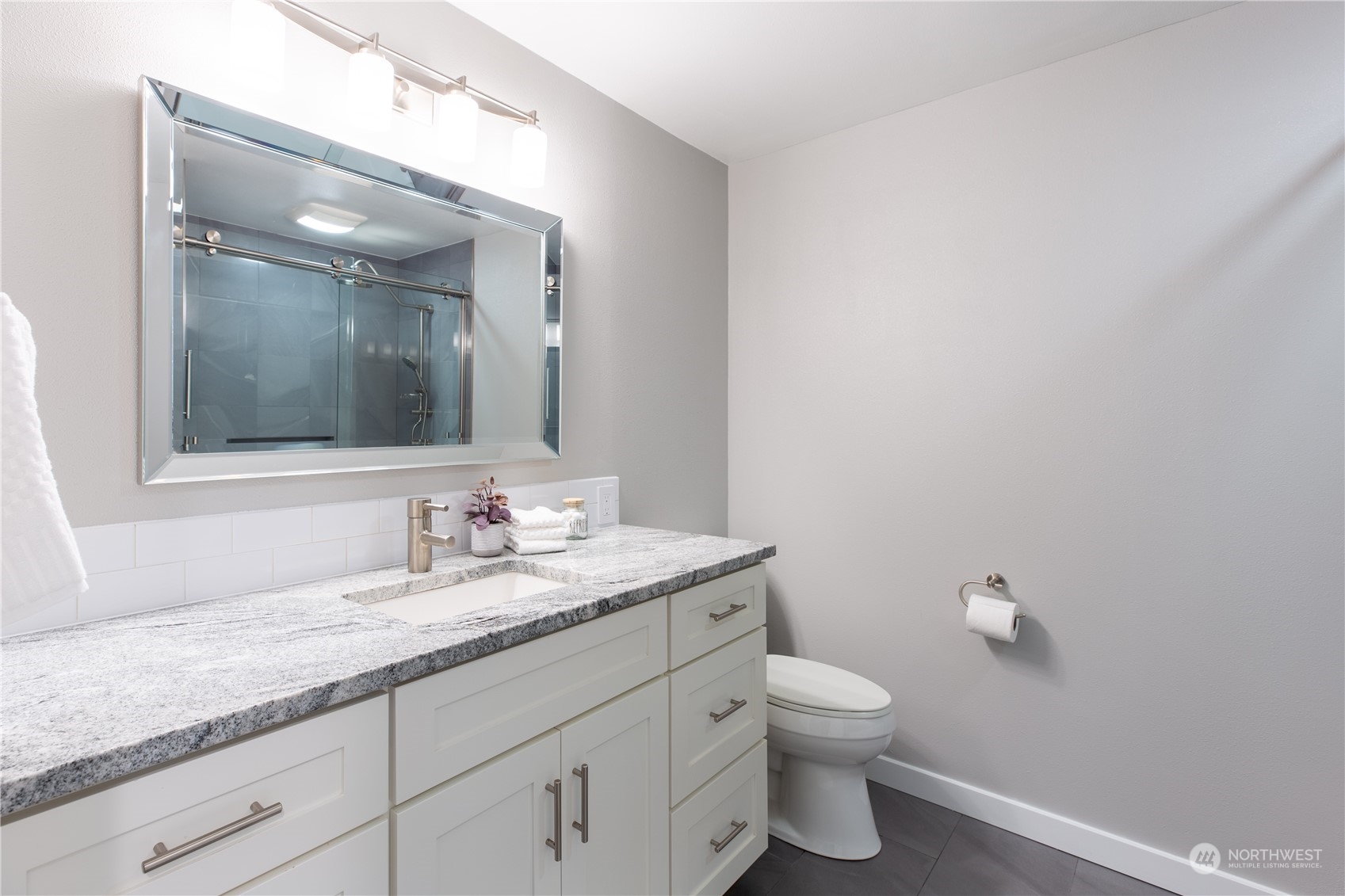 8498 Talbot Road Edmonds, WA 98026 - Photo 20 of 30 a bathroom with a granite countertop sink a toilet and a mirror