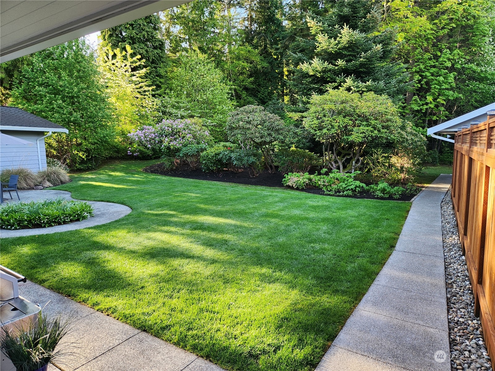 8498 Talbot Road Edmonds, WA 98026 - Photo 29 of 30 a view of a backyard with potted plants and large trees