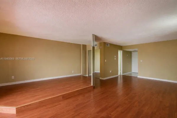 a view of an empty room with wooden floor