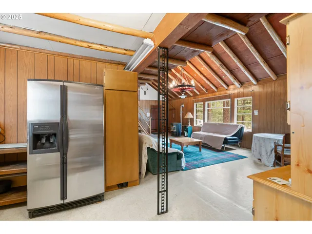 a living room with furniture a couch and a kitchen view
