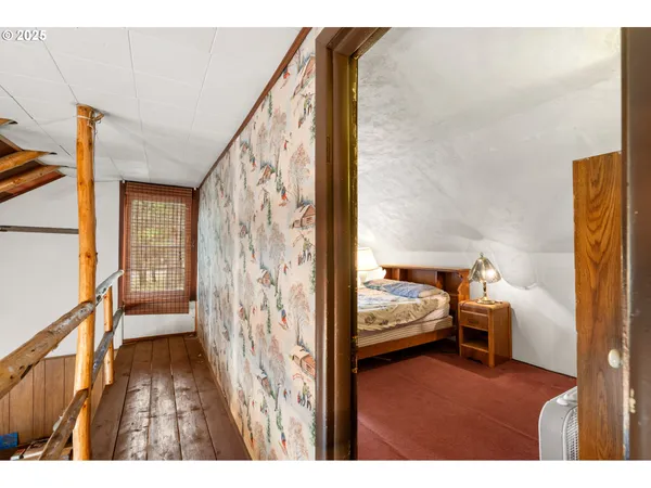 a view of a bedroom with furniture and wooden floor