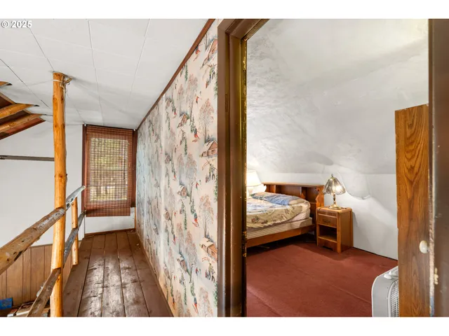 a view of a bedroom with furniture and wooden floor