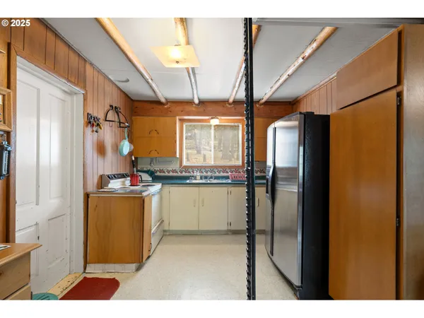 a kitchen with refrigerator and cabinets
