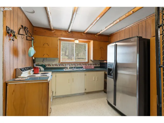 a kitchen with refrigerator and cabinets