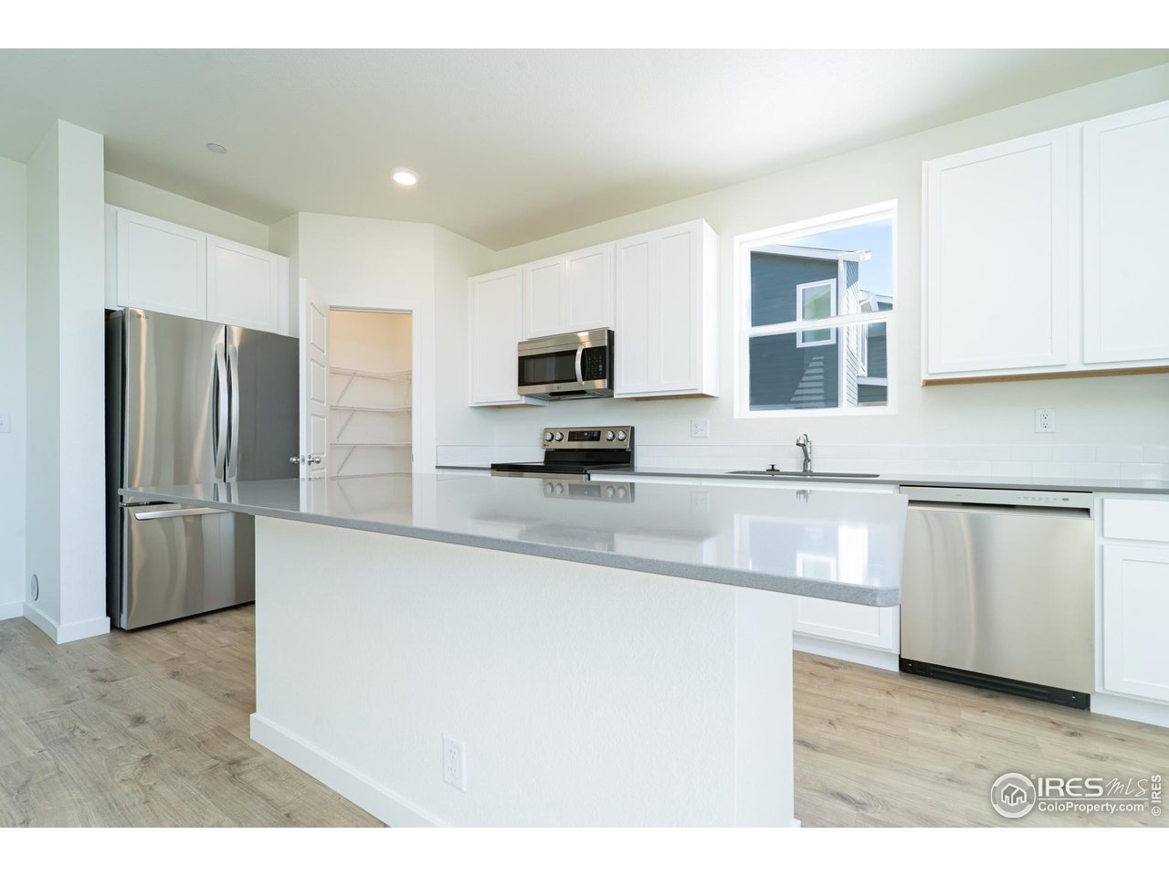 3748 Pinnacles Court Evans, CO 80620 - Photo 3 of 14 a kitchen with granite countertop a refrigerator and a sink