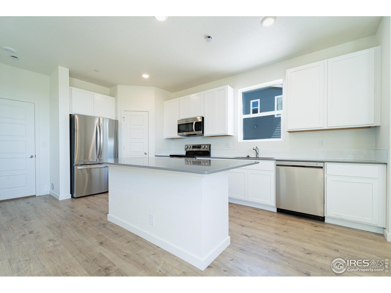 3748 Pinnacles Court Evans, CO 80620 - Photo 4 of 14 a kitchen with stainless steel appliances granite countertop a refrigerator a stove top oven a sink and dishwasher