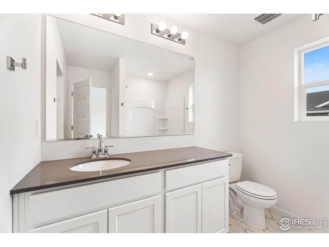 3748 Pinnacles Court Evans, CO 80620 - Photo 10 of 14 a bathroom with a sink a toilet and mirror