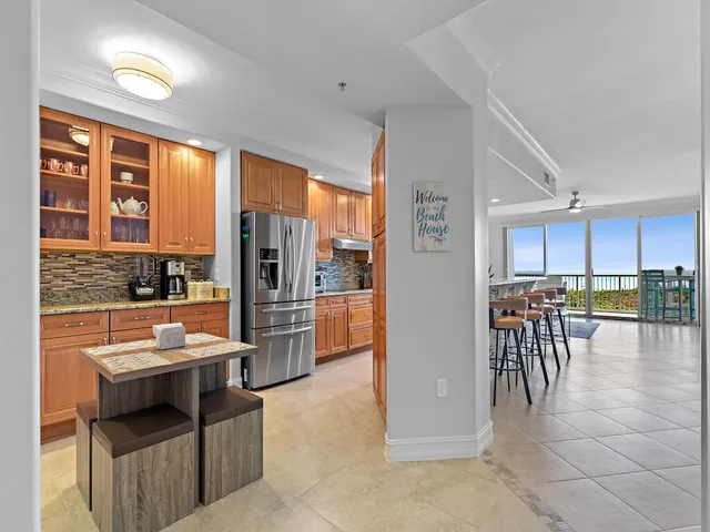 a open kitchen with stainless steel appliances kitchen island granite countertop a refrigerator and cabinets
