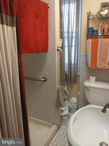 a bathroom with a sink a toilet and shower curtain
