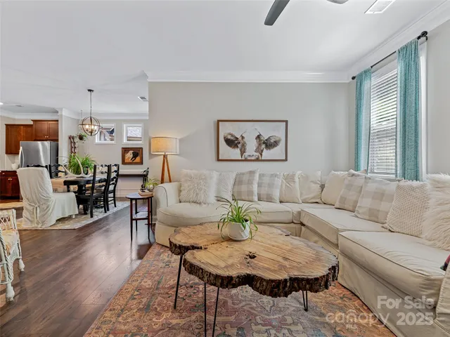 a living room with furniture kitchen view and a window