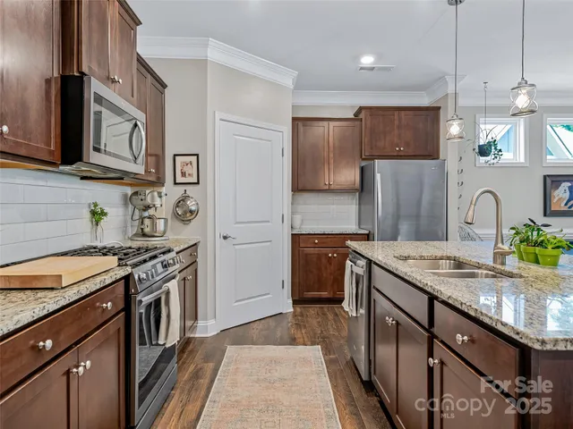 a kitchen with stainless steel appliances granite countertop a sink stove and refrigerator