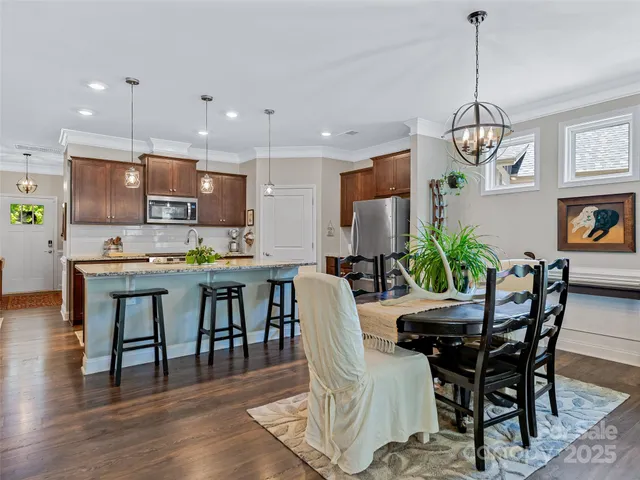 a dining room filled chandelier and wooden floor