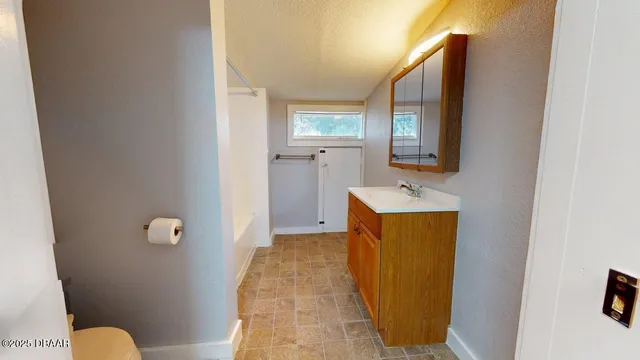 a bathroom with a sink and mirror with toilet