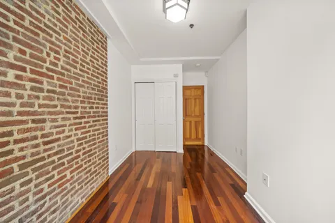 a view of a room with wooden floor and brick walls