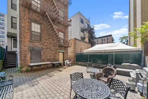 a backyard of a house with table and chairs