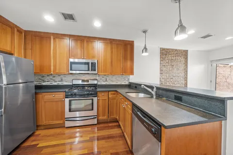 a kitchen with stainless steel appliances granite countertop a sink stove and refrigerator