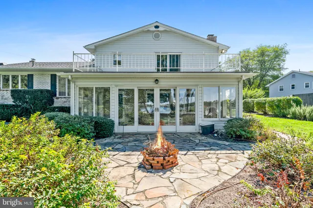 a kitchen with stainless steel appliances granite countertop a refrigerator a sink a stove a dining table and chairs