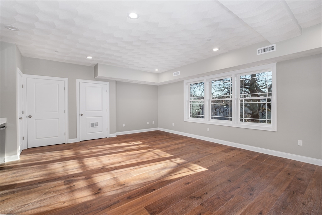 119-121 Addison Street, Unit 3 Boston, MA 02128 - Photo 3 of 13 a view of an empty room with wooden floor and a window