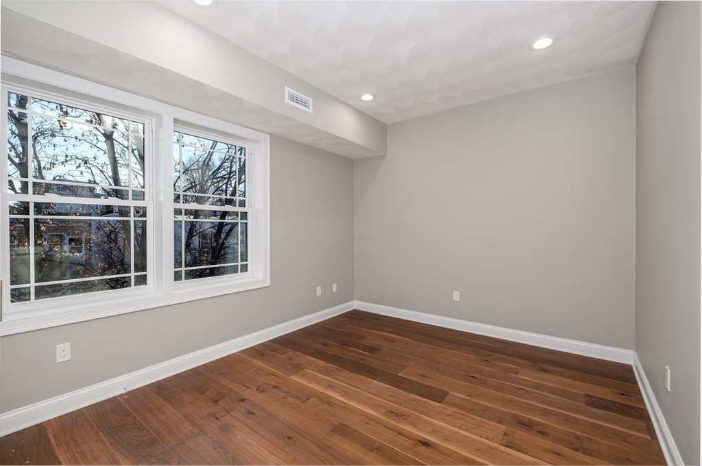 119-121 Addison Street, Unit 3 Boston, MA 02128 - Photo 4 of 13 a view of empty room with wooden floor and fan