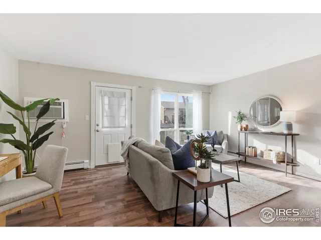 a living room with furniture a window and a wooden floor