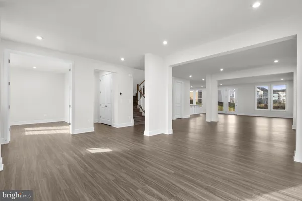a view of an empty room with wooden floor and a cabinet