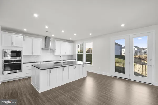 a large kitchen with stainless steel appliances granite countertop a large stove top oven and cabinets