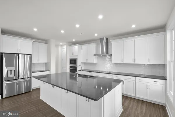a kitchen with kitchen island a counter top space cabinets and stainless steel appliances
