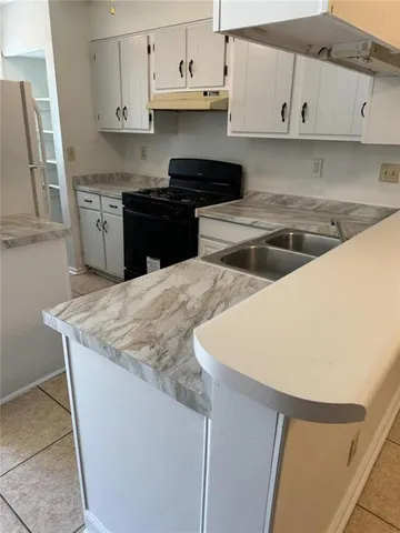 a kitchen with stainless steel appliances granite countertop a sink a stove and a refrigerator