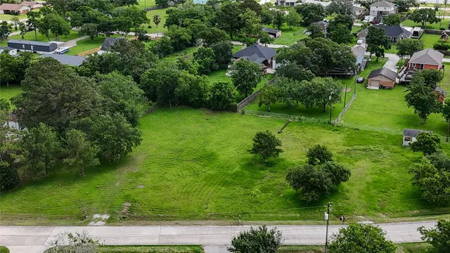 an aerial view of residential houses with outdoor space and trees