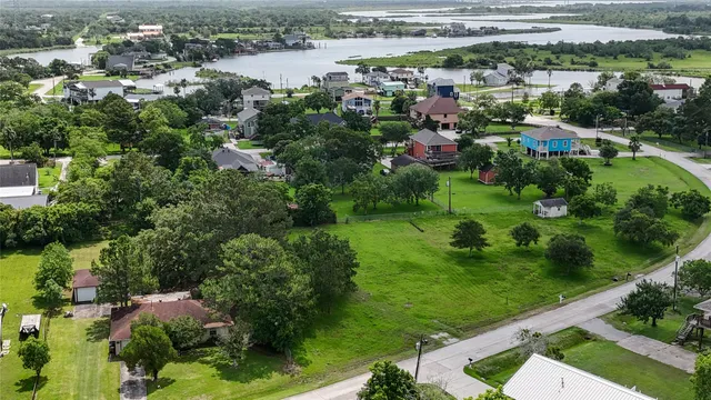 an aerial view of city lake and residential houses with outdoor space and trees