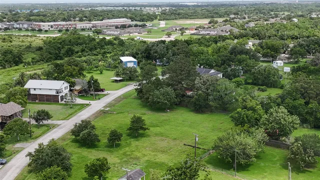 an aerial view of residential houses with outdoor space and trees