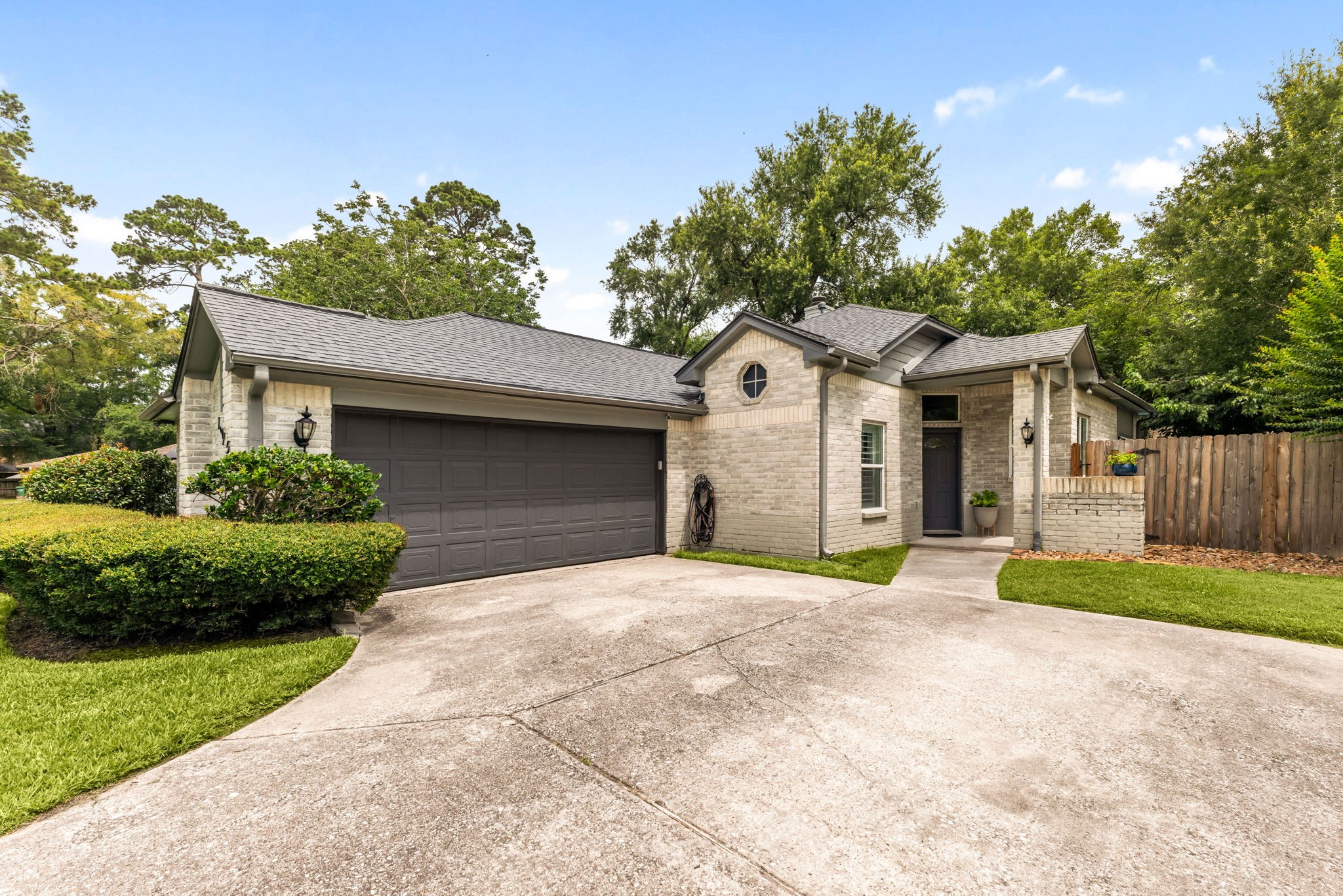 1915 Mercoal Drive Spring, TX 77386 - Photo 3 of 50 Modern front elevation with a spacious driveway, two-car garage, and attractive stone accents.