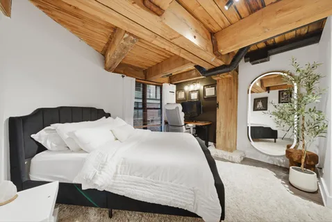a bedroom with a bed a couch and the view of en suite bathroom