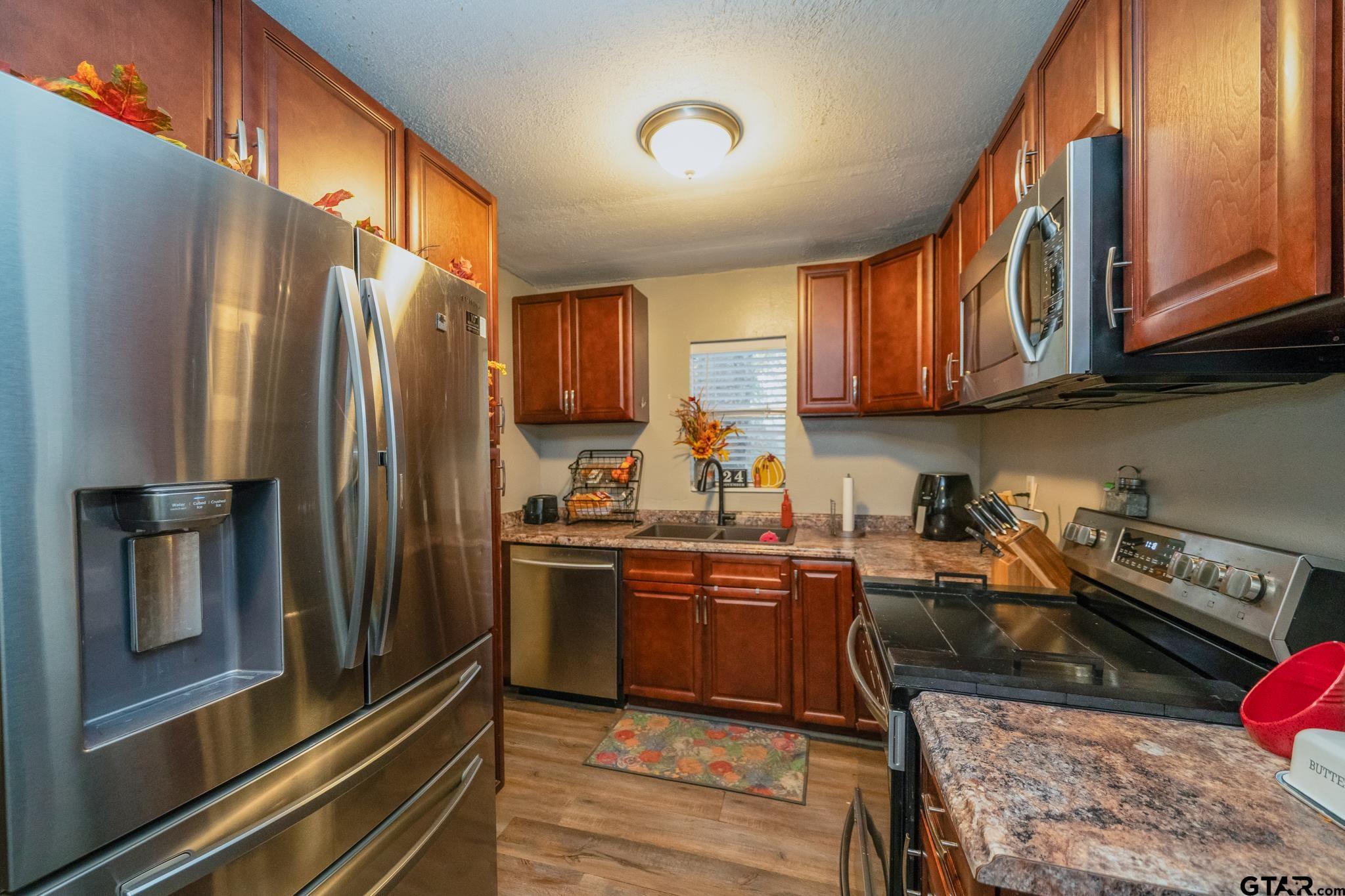 208 East Center Street White Oak, TX 75693 - Photo 12 of 31 a kitchen with stainless steel appliances granite countertop a refrigerator a stove and a sink