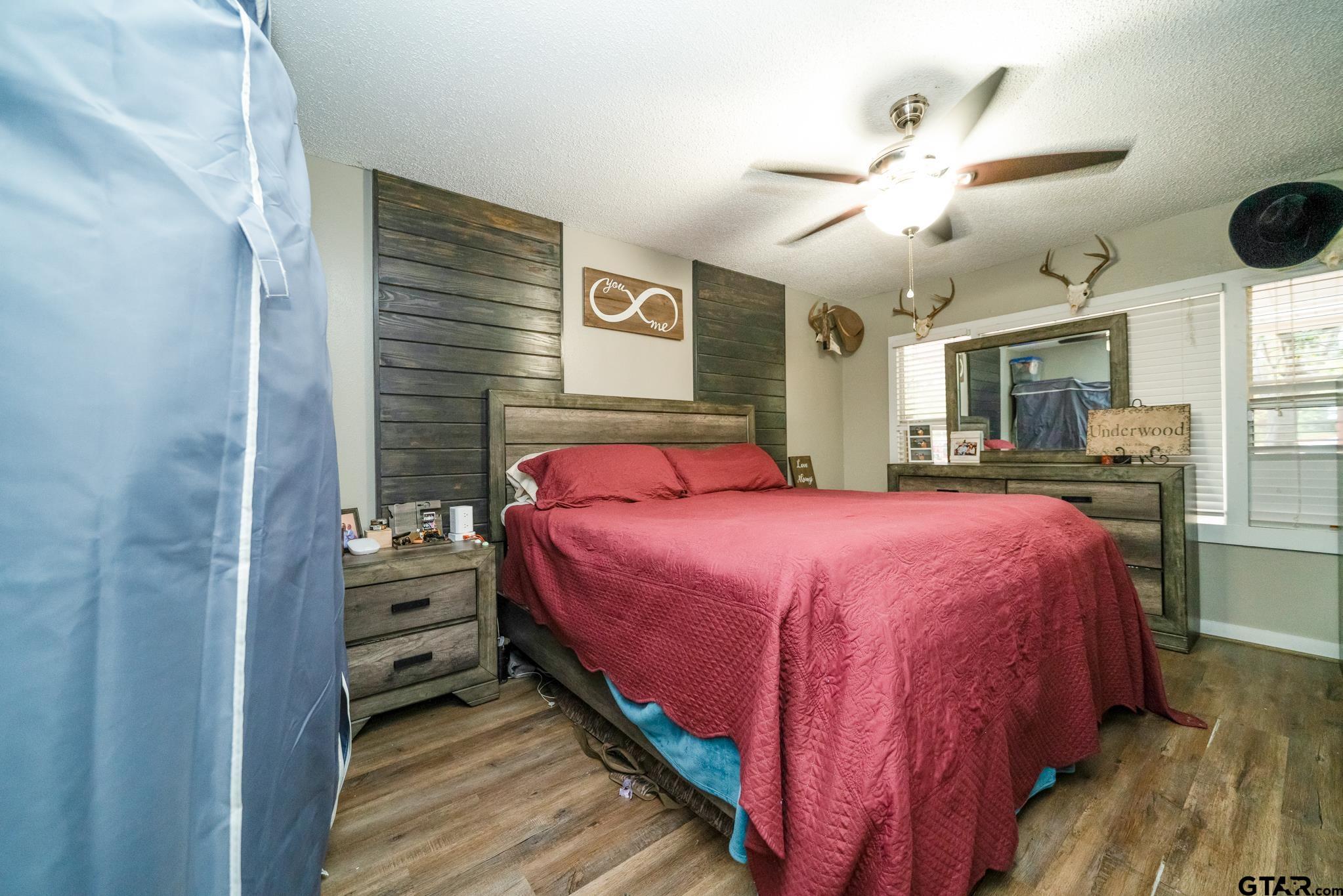 208 East Center Street White Oak, TX 75693 - Photo 20 of 31 a bedroom with a bed and a chandelier