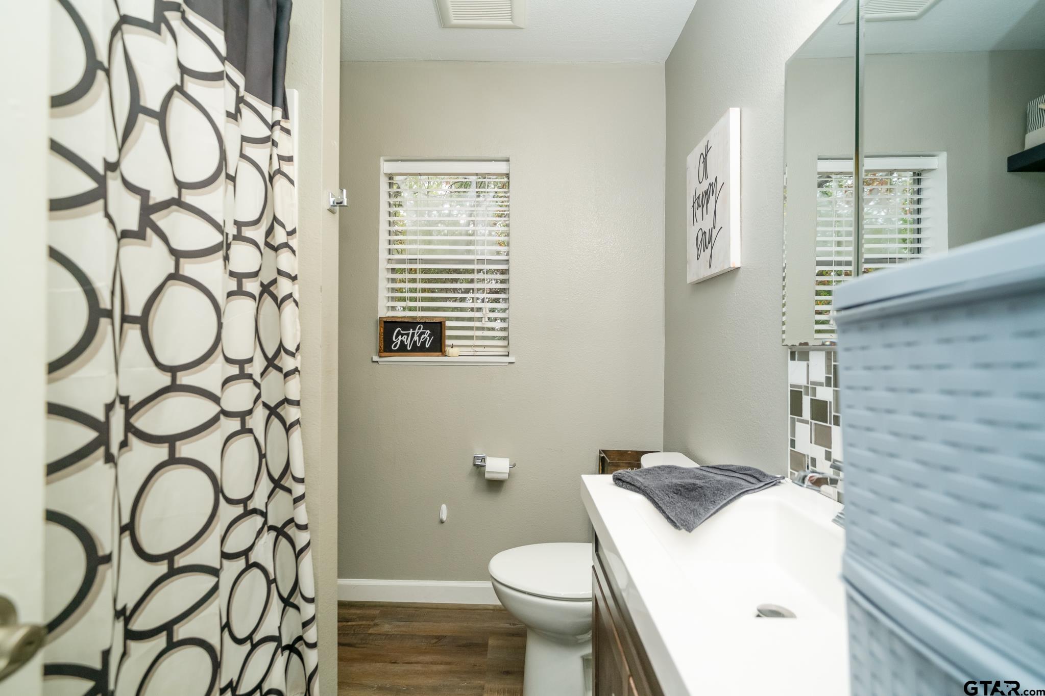 208 East Center Street White Oak, TX 75693 - Photo 23 of 31 a bathroom with a granite countertop sink and a toilet
