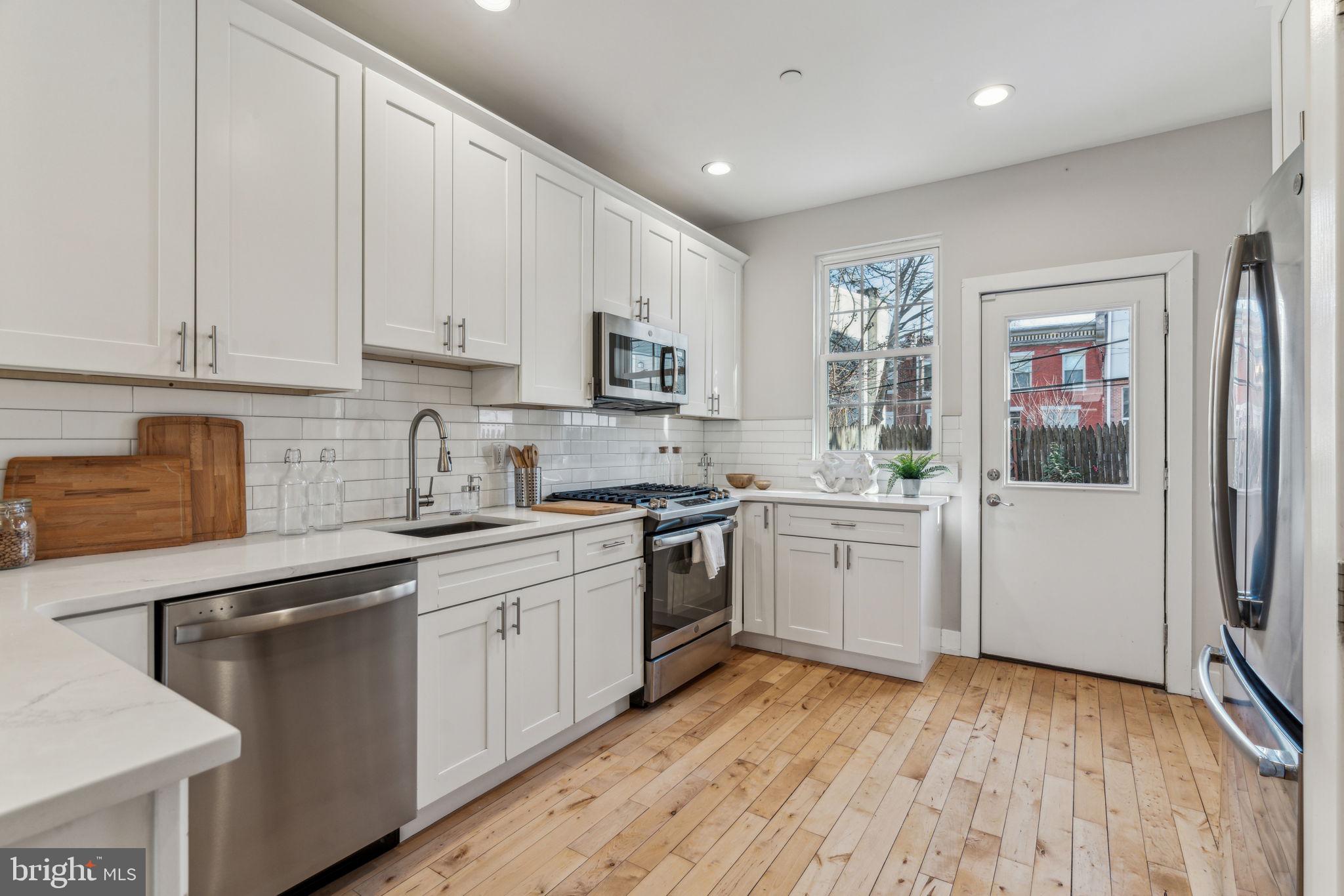 1335 North 30th Street Philadelphia, PA 19121 - Photo 11 of 58 a kitchen with a sink cabinets stainless steel appliances and a window