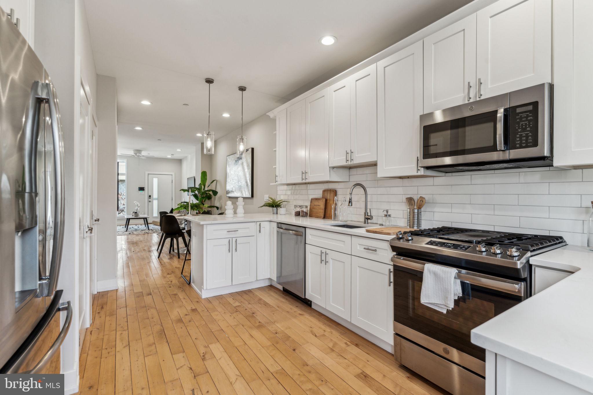 1335 North 30th Street Philadelphia, PA 19121 - Photo 12 of 58 a kitchen with stainless steel appliances kitchen island granite countertop a stove a sink and a microwave