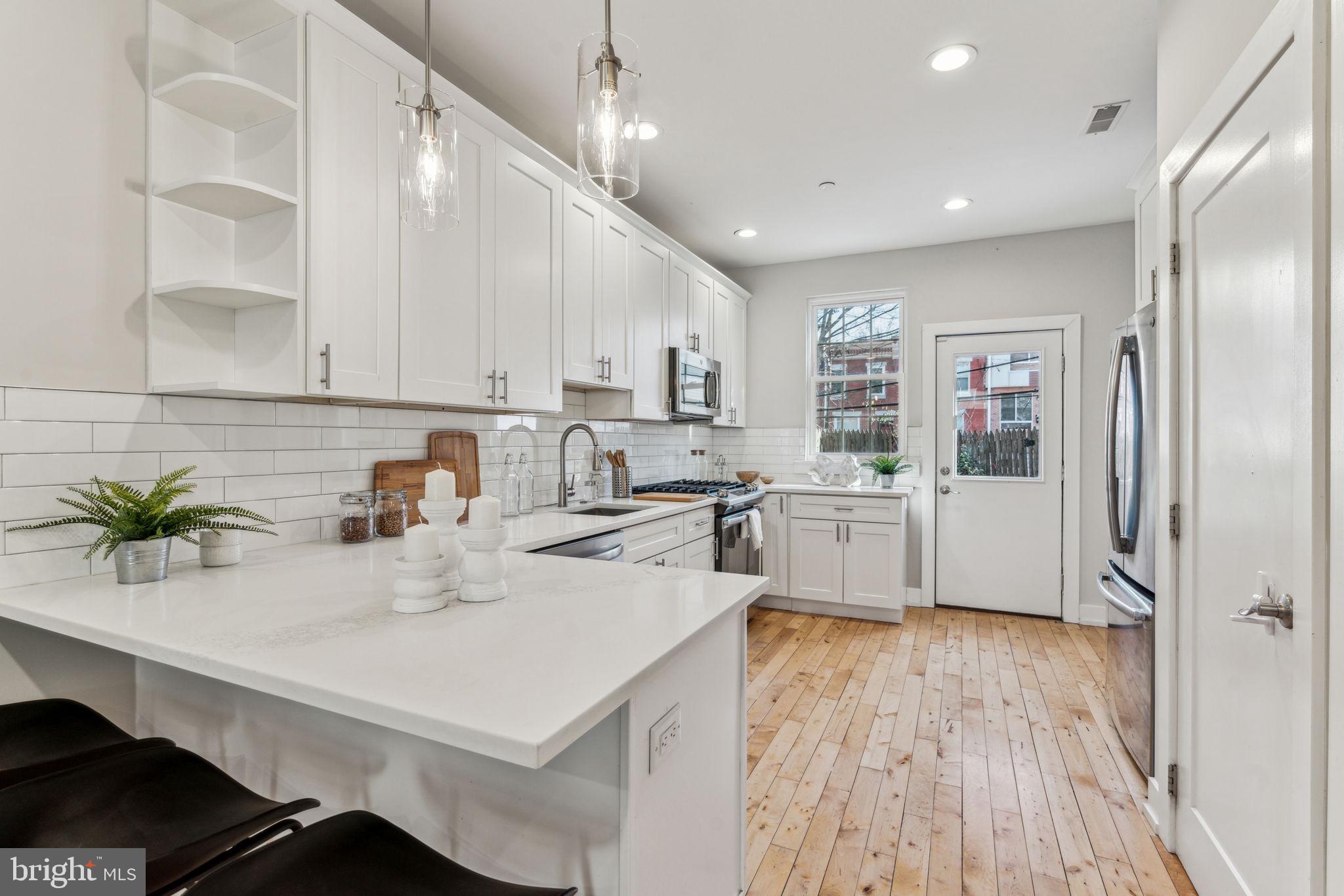 1335 North 30th Street Philadelphia, PA 19121 - Photo 9 of 58 a kitchen with kitchen island a counter top space a sink stainless steel appliances and cabinets