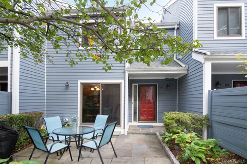 a patio with a table and chairs and potted plants