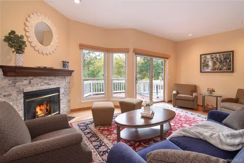 a living room with furniture a fireplace and a large window