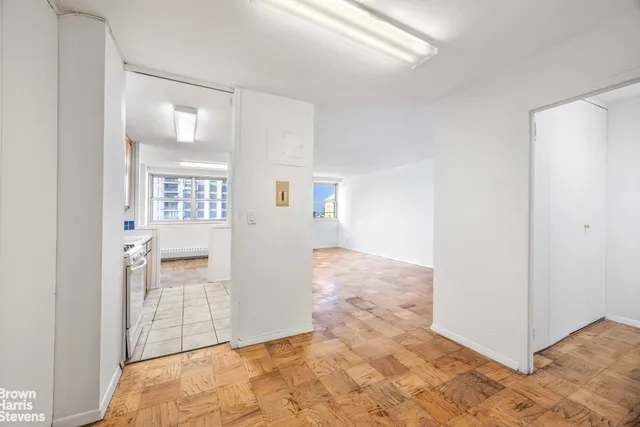 a view of a kitchen with wooden floor and a window