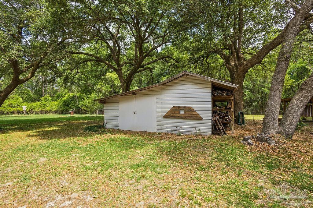8938 Pioneer Road Holt, FL 32564 - Photo 34 of 44 a house with trees in front of it