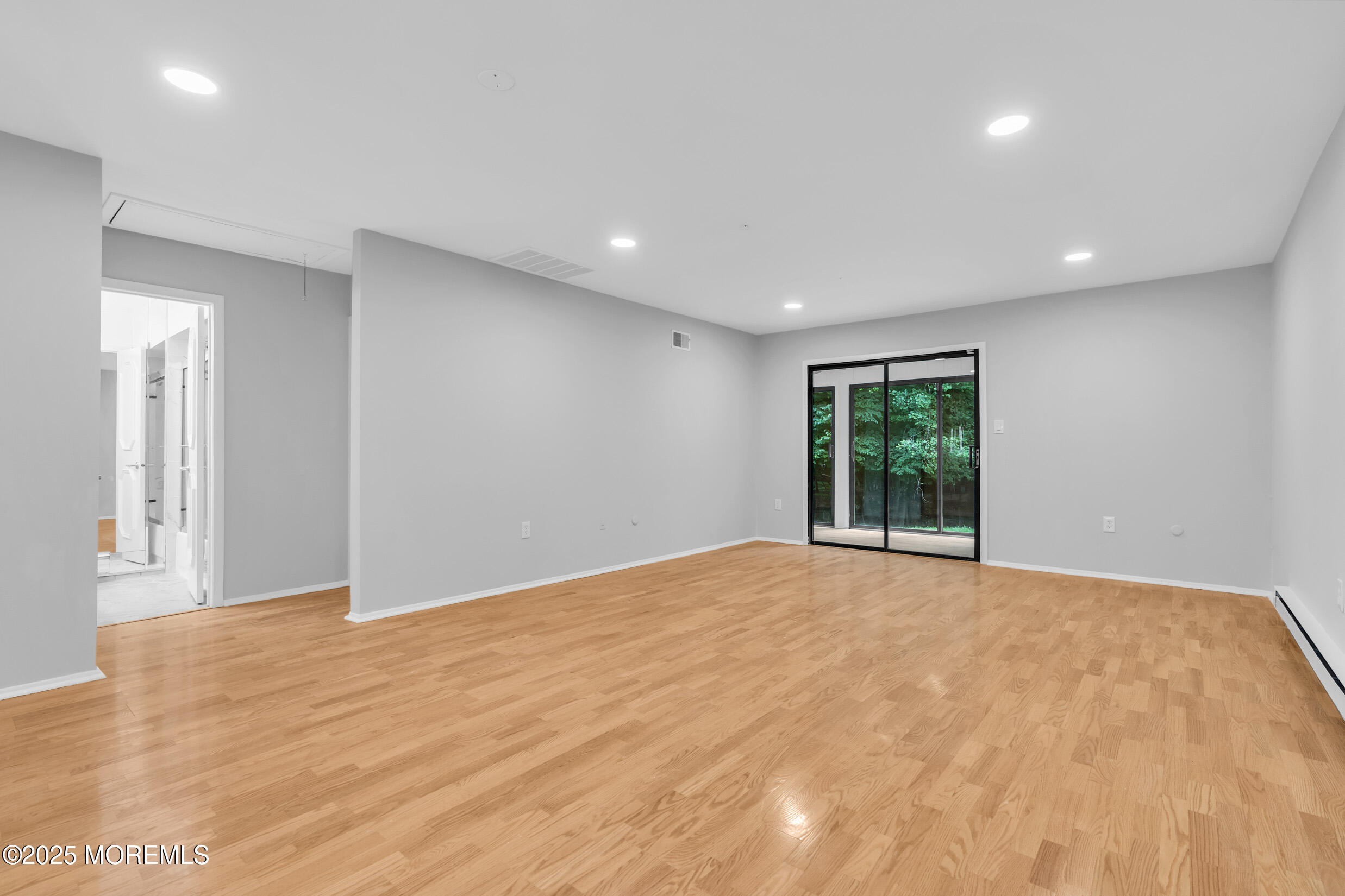70 Overlook Way, Unit A Manalapan, NJ 07726 - Photo 6 of 20 a view of an empty room with wooden floor and a window