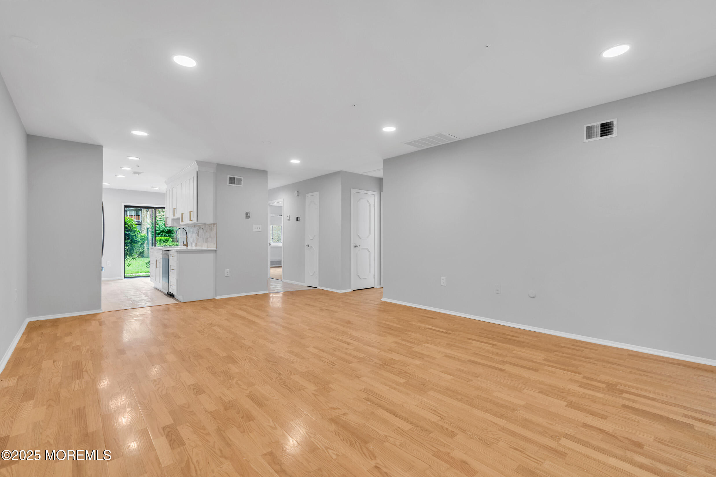 70 Overlook Way, Unit A Manalapan, NJ 07726 - Photo 7 of 20 a view of an empty room with wooden floor and a window